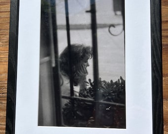 Vintage Film Photograph “Through the Window” – c. 1970 | Black & White Candid Portrait | Framed 12x16