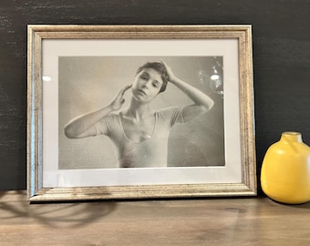 Vintage zwart-wit portretfoto van een danseres in een turnpakje.