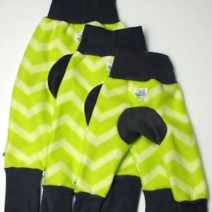 Puede incluir: Tres pares de pantalones para perros de diferentes tamaños. Los pantalones son de color verde lima con un estampado de chevron blanco, parches en las rodillas de color gris oscuro y puños y cinturillas de cuello alto de color gris oscuro. Cada par tiene una pequeña etiqueta que dice "Orient Express".