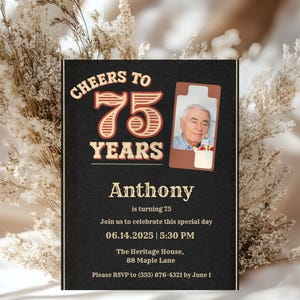Op de afbeelding: Een zwarte uitnodigingskaart met de tekst "Cheers to 75 Years" in vintage stijl. De kaart bevat een foto van een man, de naam "Anthony" en evenementdetails: datum, tijd en locatie. RSVP-informatie is ook voorzien.