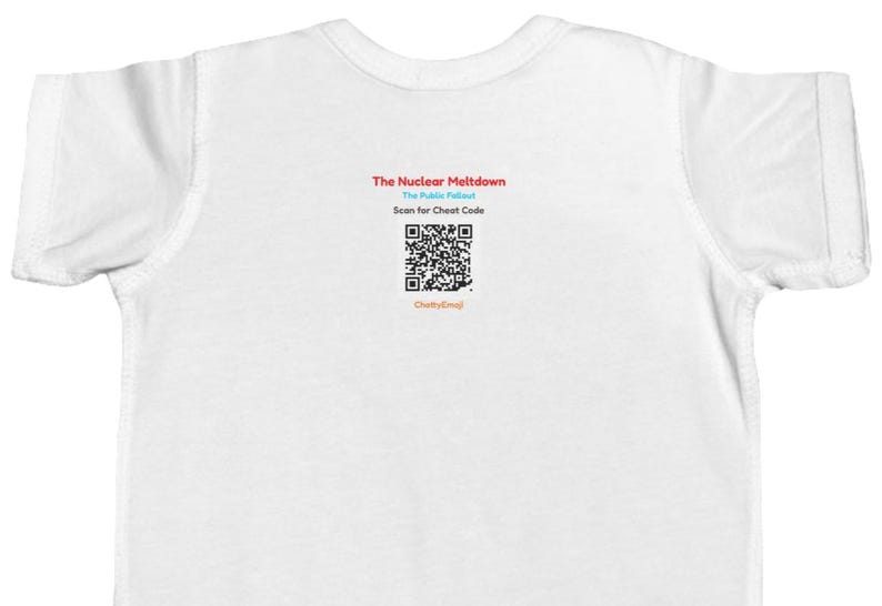 Puede incluir: Una camiseta blanca de manga corta con texto centrado que dice The Nuclear Meltdown, The Public Fallout, Scan for Cheat Code y ChattyEmoji, junto con un c&oacute;digo QR en blanco y negro situado entre las l&iacute;neas de texto.
