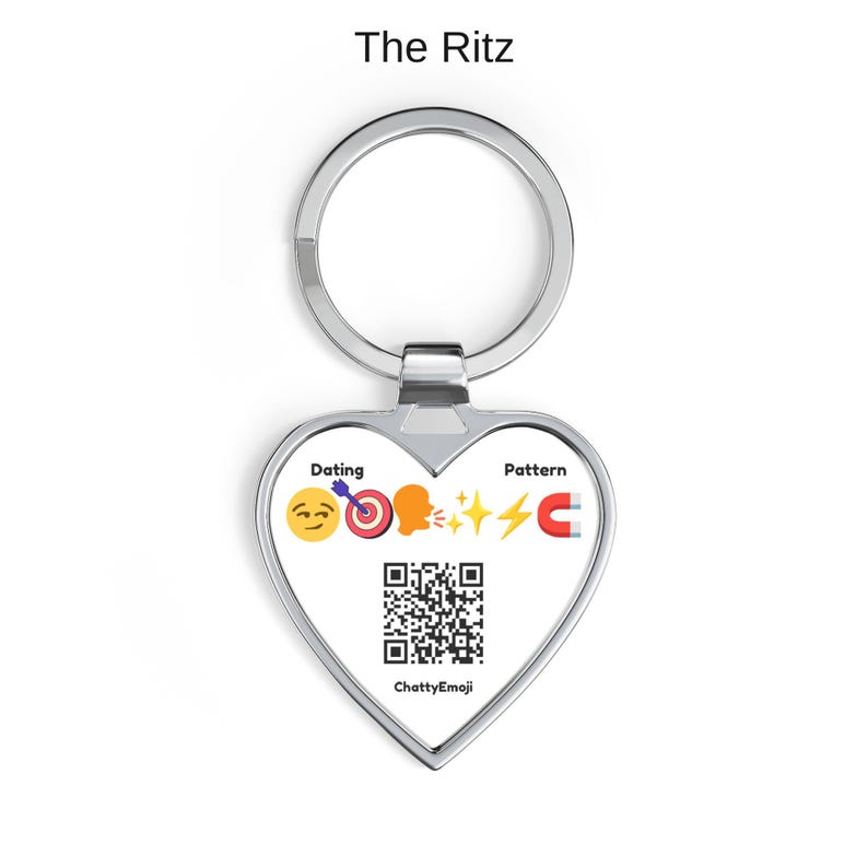Puede incluir: Un llavero de plata en forma de coraz&oacute;n con el texto The Ritz en la parte superior. El centro muestra las palabras Dating y Pattern, una secuencia de emojis que incluye una sonrisa, diana, cabeza hablando, destellos, rayo e im&aacute;n, y un c&oacute;digo QR.