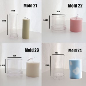 May include: Four clear plastic candle molds with finished candles inside. The molds are labeled "Mold 21", "Mold 22", "Mold 23", and "Mold 24". The candles are in various colors and sizes. The molds are 6.5 cm, 6 cm, 8 cm, and 7 cm in diameter. The candles are 15 cm, 6.5 cm, 8.5 cm, and 11.5 cm tall.