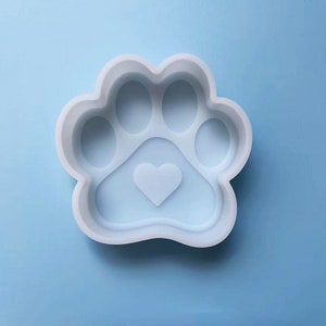 Può includere: Stampo in silicone bianco a forma di impronta di zampa con un cuore al centro. Lo stampo è progettato per realizzare oggetti in resina.