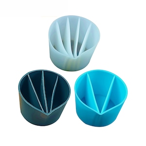 Op de afbeelding: Drie verdeelde siliconen containers in wit, blauw en grijs. Elke container heeft drie secties en is vormgegeven als een beker.