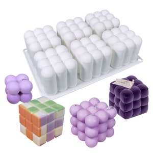 Peut inclure: Un moule en silicone blanc avec 24 cavités rondes, utilisé pour fabriquer du savon ou des bougies en forme de bulles. Le moule est présenté avec trois produits finis : un savon à bulles violet, une bougie à bulles violette et un savon multicolore à motif damier.