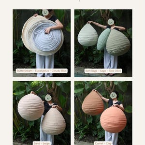 May include: A color comparison of decorative paper lanterns in various shades. The lanterns are held by a person, showcasing colors like buttercream, eucalyptus, cloudy blue, soft sage, sage, tate olive, sand, beige, camel, and clay. The text reads "Color Comparison".