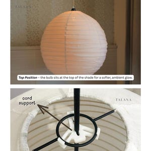 May include: A white paper lantern with a round shape, hanging from a black cord. The image shows two bulb placement options. Text on the image reads "Bulb Placement Options" and "TALANA". The lantern is designed for ambient lighting.
