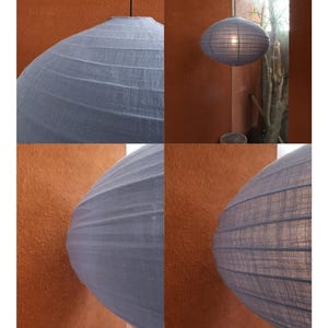 May include: Dusty blue pendant light with a textured, oval-shaped shade. The image shows the light fixture hanging from the ceiling. The text in the image says "Dusty Blue" and "Light is shaped not only by the shade, but by the bulb within."