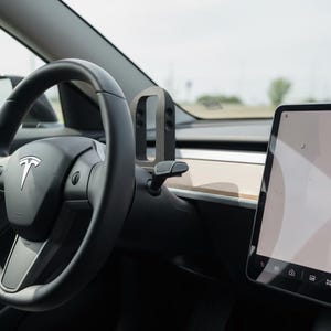 Puede incluir: Vista interior de un coche Tesla, que muestra el volante negro con el logotipo de Tesla, una pantalla digital y el salpicadero. La pantalla muestra un gráfico.