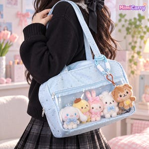 May include: A light blue tote bag with a star pattern and a clear front pocket containing five small plush animal toys. The bag features a zip closure, two shoulder straps, and a hanging brown bear charm with a yellow star emblem.