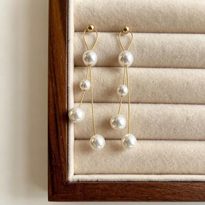 Minimalistische Perlen Ohrringe Mit Elegantem Goldenen Dangle Design