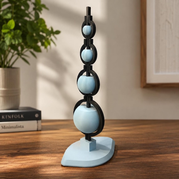 A $4,499 self-balancing kinetic desk sculpture — the kind of perpetual-motion-feeling object that stops every visitor in their tracks and demands an explanation.