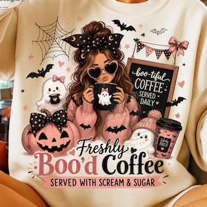 May include: A cream-colored sweatshirt featuring a graphic of a person with heart-shaped sunglasses, a bow, and a coffee mug. The design includes a pumpkin, a ghost, a chalkboard sign reading 'boo-tiful COFFEE SERVED DAILY', and 'Freshly Boo'd Coffee'.