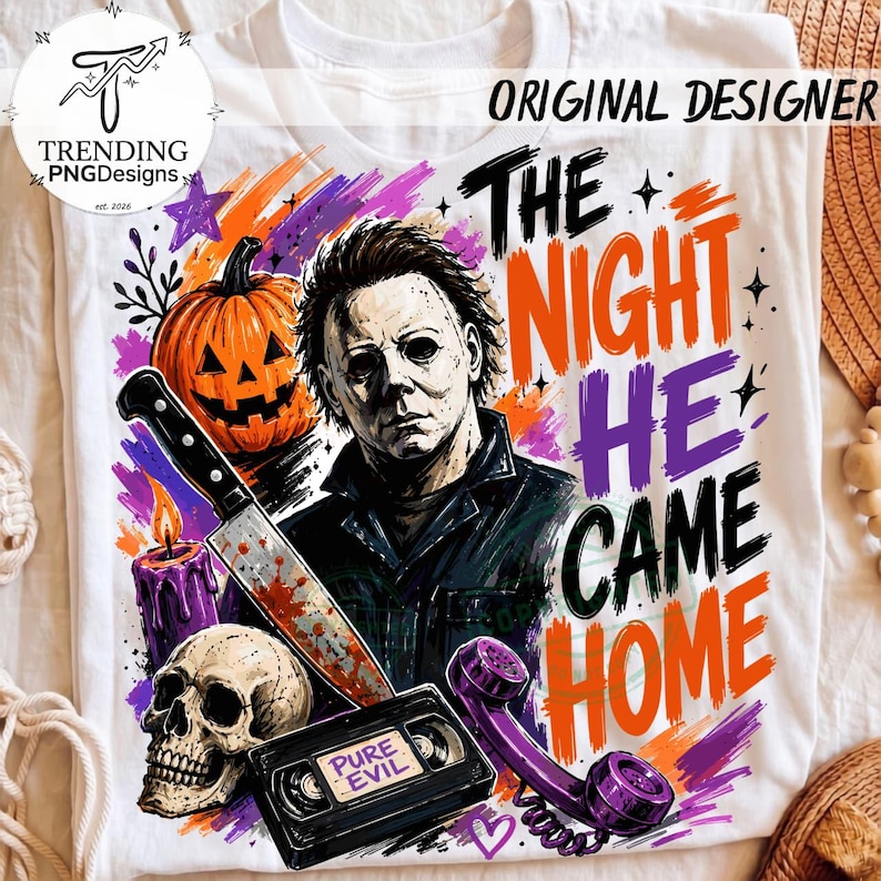 Puede incluir: Una camiseta blanca con un estampado gr&aacute;fico de un personaje de pel&iacute;cula de terror, una calabaza, una calavera, un cuchillo ensangrentado, una vela morada y una cinta VHS etiquetada PURE EVIL. El texto dice THE NIGHT HE CAME HOME.