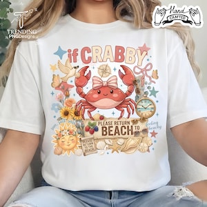 May include: White t-shirt featuring a cartoon crab with a bow, surrounded by beach-themed graphics and the text "if CRABBY, PLEASE RETURN TO BEACH". Includes a sun, flowers, and a vintage clock.