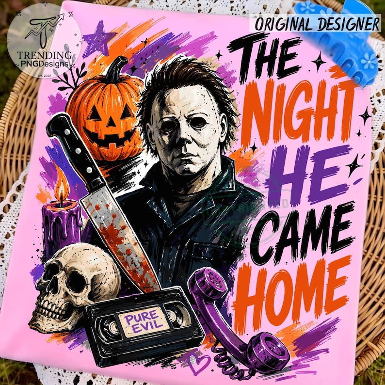 Puede incluir: Un estampado gr&aacute;fico rosa con Michael Myers, una calabaza, un cuchillo ensangrentado, una calavera, una vela morada, una cinta VHS con la etiqueta PURE EVIL y un tel&eacute;fono de disco morado con el texto THE NIGHT HE CAME HOME en letras negras y naranjas.