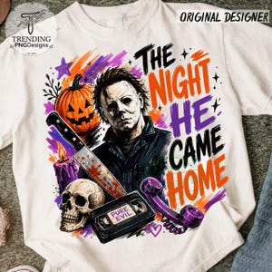 Puede incluir: Una camiseta blanca con un gr&aacute;fico de un personaje de pel&iacute;cula de terror, una calabaza, una calavera, un cuchillo, una cinta VHS con la etiqueta PURE EVIL y un tel&eacute;fono morado. El texto THE NIGHT HE CAME HOME aparece en letras naranja y moradas.