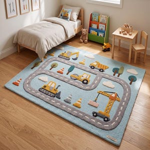 Puede incluir: Alfombra infantil azul claro con diseño de carretera y vehículos de construcción. La alfombra presenta una carretera gris con vehículos de construcción amarillos, árboles, nubes y conos de tráfico naranjas. La alfombra está en un dormitorio infantil.