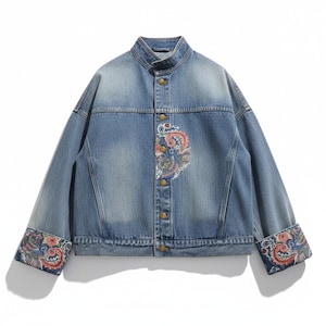 May include: A light blue denim jacket with a mandarin collar and button closure. The jacket features colourful embroidered paisley designs on the front and cuffs. The cuffs are folded up, revealing the patterned fabric.