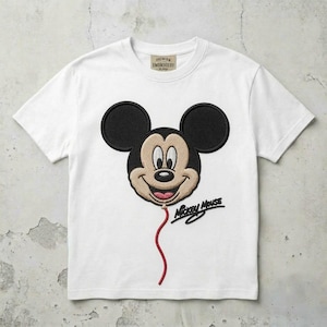May include: A white short-sleeve t-shirt featuring a large embroidered Mickey Mouse head shaped like a balloon. The design includes a red string, the text "Mickey Mouse" in black script, and a "Premium Embroidery" label at the inner neckline.