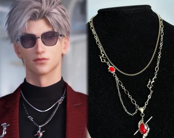 Puede incluir: Un collar de cadenas múltiples en tono plateado con pequeños detalles de cabujones ovalados rojos y un colgante central con forma de ala o llama estilizada con una incrustación de piedra roja. El diseño incluye cadenas de eslabones finos.