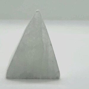 Op de afbeelding: Een lichtgekleurd, doorschijnend object in de vorm van een piramide. De piramide heeft een glad, licht getextureerd oppervlak en een puntige top. Het object staat tegen een effen witte achtergrond.