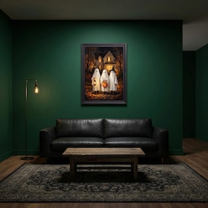 Puede incluir: Una impresi&oacute;n de arte mural enmarcada que representa a tres figuras vestidas con disfraces de fantasmas blancos frente a una casa por la noche. Un fantasma sostiene una linterna encendida, otro lleva una calabaza y el tercero usa un sombrero de bruja negro.