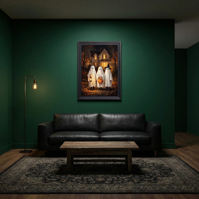Puede incluir: Una impresi&oacute;n de arte mural enmarcada que representa a tres figuras vestidas con disfraces de fantasmas blancos frente a una casa por la noche. Un fantasma sostiene una linterna encendida, otro lleva una calabaza y el tercero usa un sombrero de bruja negro.