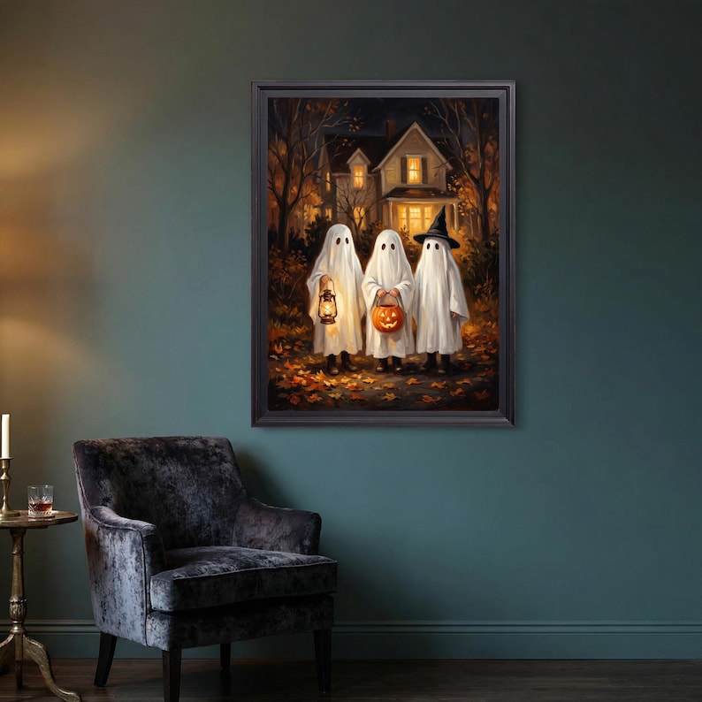 Puede incluir: Una impresi&oacute;n art&iacute;stica enmarcada que muestra a tres figuras vestidas con disfraces de fantasmas blancos sobre un camino cubierto de hojas de oto&ntilde;o. Un fantasma sostiene una linterna brillante, otro lleva una calabaza y el tercero usa un sombrero de bruja.