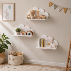 May include: Three white wall-mounted shelves shaped like clouds. The top shelf holds a teddy bear, a wooden star, and a wooden car. The middle shelf holds a potted plant, a wooden camera, and a rainbow. The bottom shelf holds books and a star.