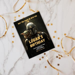May include: A black birthday invitation with gold text and a Star Wars theme. The invitation features The Mandalorian and Grogu. The text reads "May the Force Be With You On Logan's Birthday". Gold stars and ribbon decorate the background.