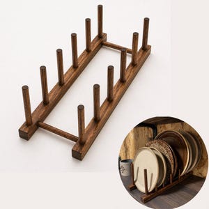 Könnte beinhalten: Ein dunkelbrauner Tellerständer aus Holz mit vertikalen Stiften zum Halten von Tellern. Der Ständer ist rechteckig mit doppelseitigem Design und wird mit einer Vielzahl von Tellern in einem zweiten Bild gezeigt. Eine praktische Küchenaufbewahrungslösung.