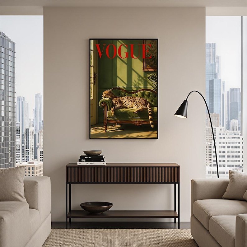 May include: A framed wall art print featuring a cheetah resting on a green tufted sofa in a sunlit room, with the word VOGUE printed in bold red letters at the top. The artwork displays a warm, golden light casting long shadows across the scene.