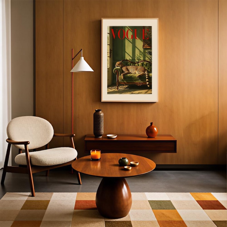 May include: A framed wall print featuring a Vogue magazine cover with a cheetah resting on a green sofa. The room includes a cream-colored armchair, a round wooden coffee table, a floor lamp, and a floating shelf with decorative ceramic vases.