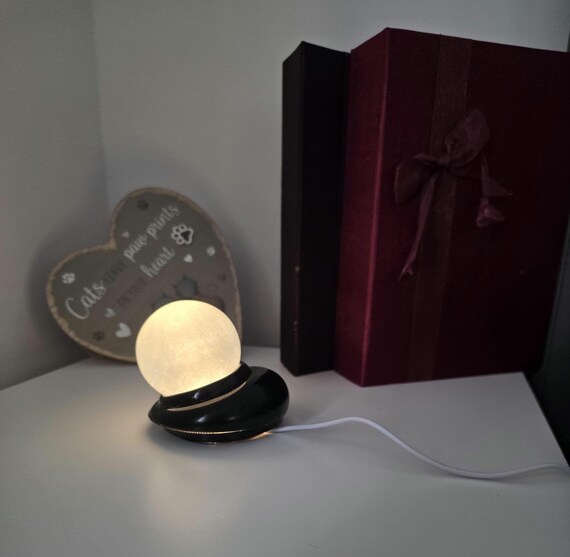A resin-cast moon lamp where the handmade resin work creates unique internal texture and glow — far more interesting than the mass-produced plastic moon lamps flooding Amazon.