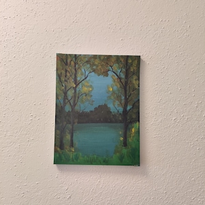 Puede incluir: Una pintura acrílica de un paisaje sereno. La obra representa una escena de lago enmarcada por árboles con follaje amarillo y verde. El agua es de color verde azulado y el cielo es azul claro. Hierba verde en la parte inferior de la pintura.