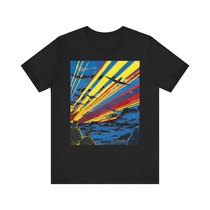 May include: Black t-shirt with a graphic depicting aeroplanes soaring through a sky of yellow, red, and blue streaks. The design includes silhouettes of figures in the foreground.
