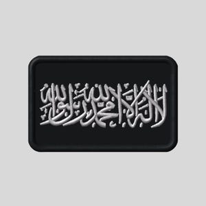 May include: Black rectangular patch featuring white embroidered Arabic calligraphy. The patch has rounded corners and a black border. The calligraphy is detailed and appears to be a religious text.