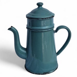 May include: A teal enamel coffee pot with a lid and handle. The pot has a long spout and a rounded body. The handle is curved, and the lid has a small knob. The pot is likely vintage or antique.