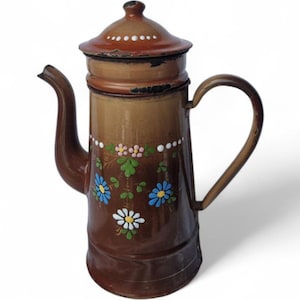 May include: A vintage brown enamel coffee pot with a lid and handle. The pot is decorated with hand-painted blue, white, and pink floral designs. The pot has a spout and a handle. The pot is likely used for brewing coffee.