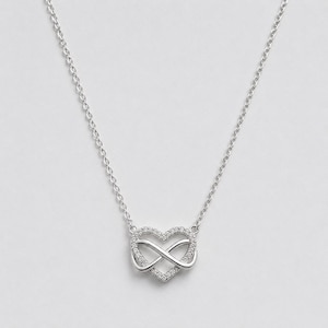 May include: A silver-toned necklace featuring a central pendant shaped like a heart intertwined with an infinity symbol. The heart outline is encrusted with small, clear, sparkling stones, and the piece hangs from a delicate, thin silver-toned chain.
