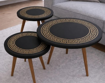 Set di tavolini impilabili con motivo a greca in oro e nero, arredamento moderno e minimalista per il soggiorno.