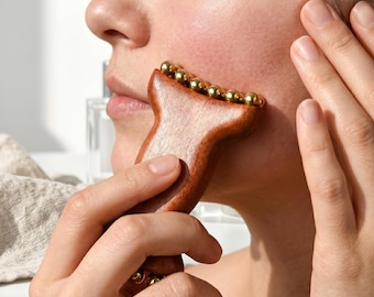 Herramienta de masaje facial Gua Sha de madera con perlas de cobre para drenaje linfático, lifting facial, antiarrugas y modelado de la mandíbula.