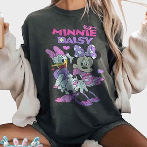 May include: A white ceramic mug with a black handle and the text "But First, Coffee" in a handwritten style. The mug is on a white surface. The mug is likely for hot beverages.