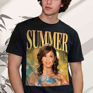 Könnte beinhalten: Ein schwarzes kurzärmeliges T-Shirt mit einem Grafikdruck auf der Brust. Der Druck zeigt das Wort SUMMER in großen goldenen Buchstaben über einem Foto einer Person mit braunen Haaren, wobei der Name Roberto in blauer Schrift darunter steht.
