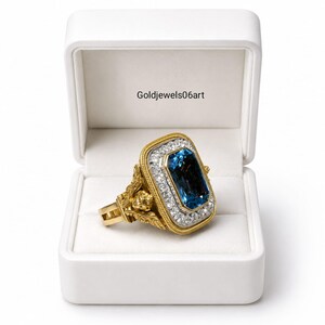 May include: A gold ring featuring a large rectangular blue gemstone surrounded by a halo of small white stones. The ring band has intricate gold detailing and is presented in a white box with the text Goldjewels06art printed on the interior.