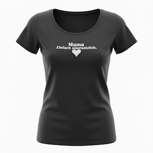 May include: Black t-shirt with a scoop neck. The shirt features the text "Mama Einfach unersetzlich" in white, with a white heart symbol below the text. The shirt is a solid color and has short sleeves.