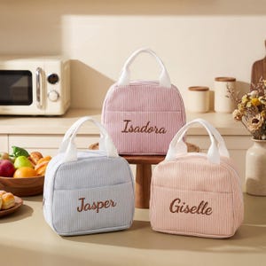 May include: A set of three ceramic mugs with a speckled, matte finish. The mugs are in shades of cream, light gray, and dark gray. Each mug has a simple, minimalist design, perfect for coffee or tea.