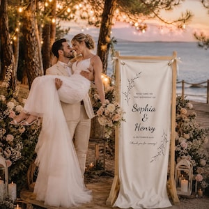 Elegant wooden wedding welcome sign with custom fabric banner, outdoor garden ceremony entrance decor, personalized wedding reception signage